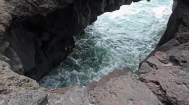 Güçlü dalgaların, kıyı şeridi boyunca volkanik kayaların oluşturduğu doğal bir kemere çarptığını hissedin..