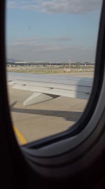 Uçak, geniş bir havaalanı görüntüsüyle pistten kalkışa hazırlanıyor..