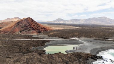 Kanarya Adaları, Lanzarote 'deki Bermeja Sahili' nin eşsiz arazisiyle çevrili canlı bir krater gölü içeren nefes kesici volkanik manzarayı keşfedin.