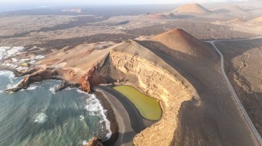 Charco Verde veya Chaco de los Clicos of Lanzarote 'nin çarpıcı uçurumlarının insansız hava aracı görüntüsü güzellikleri ve volkanik tarihi gözler önüne seriyor..