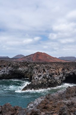 Bu engebeli kıyı şeridinde Lanzarote 'deki volkanik tepeler ve turkuaz su ile birlikte Los Hervidertos kaya oluşumları sergilenmektedir.