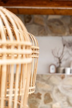 Örülmüş bir sepet tavandan sarkan ışıklar, dekorasyon malzemeleriyle iç duvarın kırsal hissini arttırıyor..