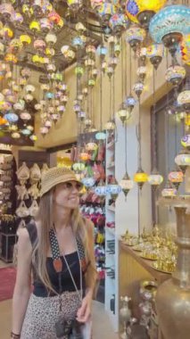 Sarışın kadın, Dubai 'de göz kamaştırıcı fenerler ve eşsiz el sanatları ile çevrili hareketli bir pazarda vakit geçirmekten hoşlanıyor.