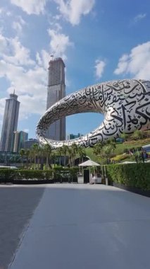 Dubai 'de mavi gökyüzü altında yüksek binalarla çevrili çarpıcı bir modern sanat eseri keşfedin. Gelecek Müzesi