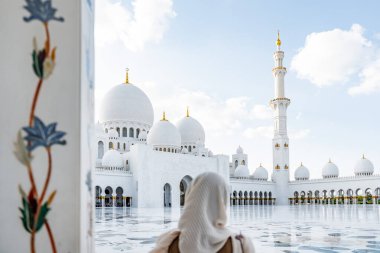 Geleneksel giysiler giymiş bir kadın görkemli şeyh zayed büyük camiye bakıyor, ünlü bir yer ve turistik mekan.