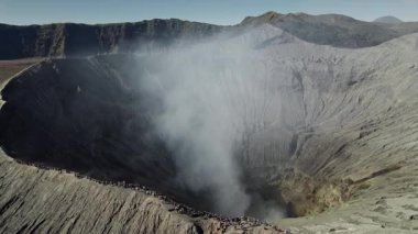 Endonezya 'daki Mount Bromo Crater' dan yükselen dumanı izleyen turistlerin insansız hava aracı görüntüsü
