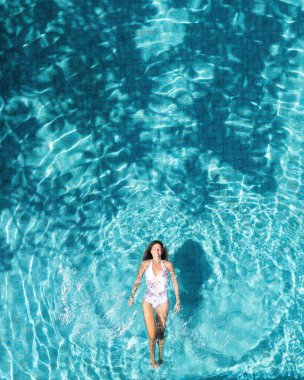 Turistin ferahlatıcı mavi bir havuzda yüzen yaz tatilinin en güzel manzarası.