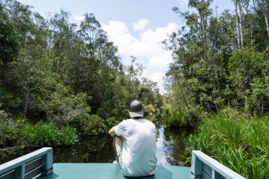 Turist, güzel bir tropikal yağmur ormanında dinlendirici bir tekne gezisinin tadını çıkarıyor.