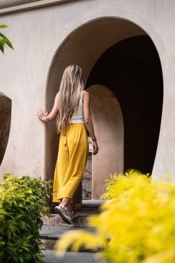 Genç kadın turistin Bali, Endonezya 'daki antik tapınak kalıntılarını keşfetmesi