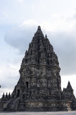 Prambanan Tapınağı 'nın etkileyici manzarası, unesko bir dünya mirası alanı. Karmaşık taş oymalarını ve bulutlu gökyüzüne karşı yükselen yapısını sergiliyor.