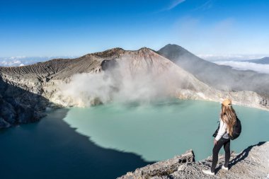 Endonezya, Banyuwangi 'de turkuaz sülfürik gölün ve kawah ijen volkanının dumanlarının tadını çıkaran dişi turist.