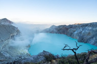Kawah ijen krateri, parlak mavi gölü ve çevreleyen engebeli arazisiyle