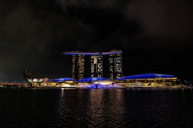 Solunda sanat müzesi olan etkileyici marina Bay Sands Oteli geceleri denize yansıyor.