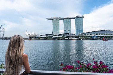 Sarışın turist Singapur 'un etkileyici ufuk çizgisine hayran, ikonik marina körfezi kumları ve sanat müzesi