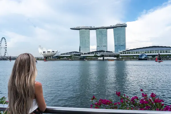 Sarışın turist Singapur 'un etkileyici ufuk çizgisine hayran, ikonik marina körfezi kumları ve sanat müzesi