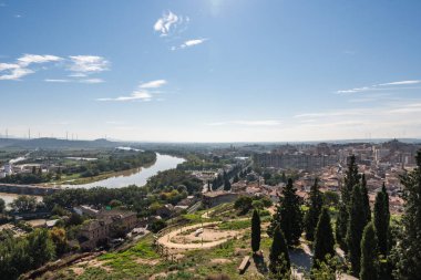 Rüzgar türbinleri arka planda güneşli bir günde İspanya 'nın Navarra kentindeki Tudela şehrinde dolaşan Ebro nehri.