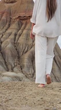 Çıplak ayakla Bardenas 'taki kumtaşı zirvesine doğru yürüyen genç bir kadın Tudela, İspanya yakınlarındaki çölde yaşıyor.