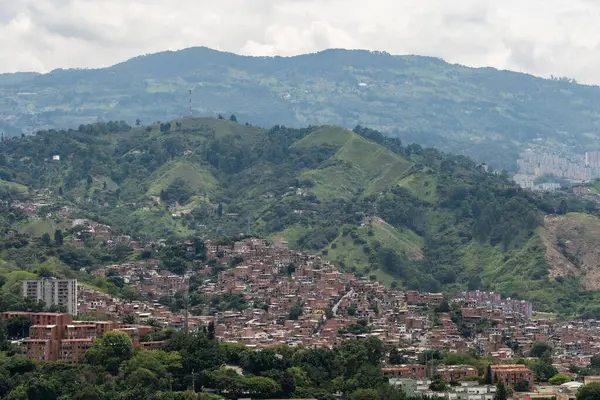 Medellin, Kolombiya 'nın yeşil tepelerine tırmanan kırmızı tuğlalı evler kentsel genişlemeyi ve yaşam tarzını gösteriyor.