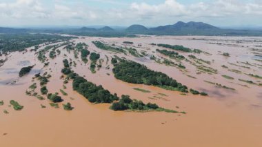 İHA görüntüleri, Laos 'taki adalar ve dağlarla çevrili Mekong nehrinin çamurlu sularında uçuyor.