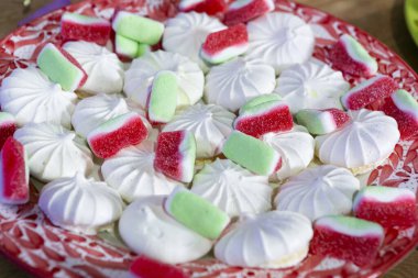 Farklı renkte tatlılar ve tatlarla dolu tepsi; sakızlar ve kurabiyeler.