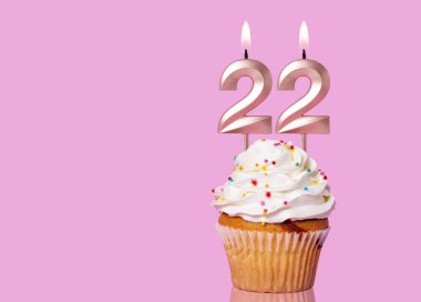 22 Numaralı Mumlu Doğum Günü Pastası Pembe Arkaplanda.