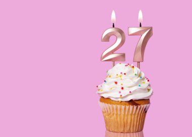 27 Numaralı Mumlu Doğum Günü Pastası Pembe Arkaplanda.