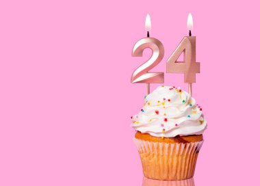 24 Numaralı Mumlu Doğum Günü Pastası Pembe Arkaplanda.
