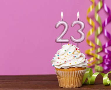 23 Numaralı Mumlu Doğum Günü Pastası Pembe Arkaplanda.