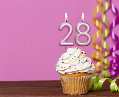 28 Numaralı Mumlu Doğum Günü Pastası Pembe Arkaplanda.