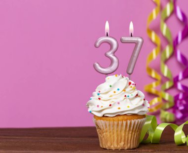 37 Numaralı Mumlu Doğum Günü Pastası Pembe Arkaplanda.