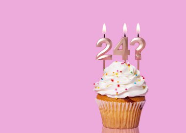 24 numaralı mumlu doğum günü pastası ve Pembe Arkaplanda Soru İşareti.