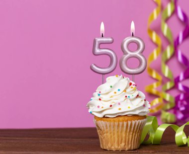 58 Numaralı Mumlu Doğum Günü Pastası Pembe Arkaplanda.