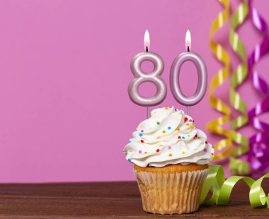 80 Numaralı Mumlu Doğum Günü Pastası Pembe Arkaplanda.