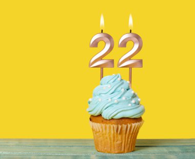 22 Numaralı Mumlu Doğum Günü Pastası Sarı Arkaplanda.