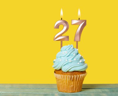 27 Numaralı Mumlu Doğum Günü Pastası Sarı Arkaplanda.