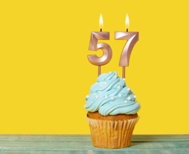 Sarı Arkaplanda 57 Numaralı Mumlu Doğum Günü Pastası.