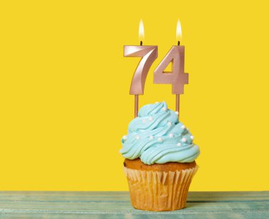 Sarı Arkaplanda 74 Numaralı Mumlu Doğum Günü Pastası.