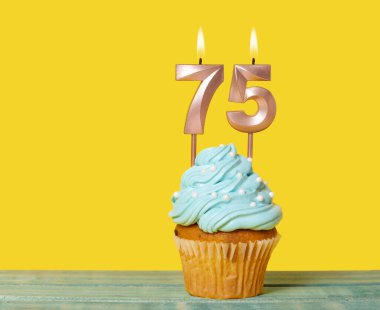 Sarı Arkaplanda 75 Numaralı Mumlu Doğum günü Pastası.