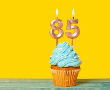 Sarı Arkaplanda 85 Numaralı Mumlu Doğum Günü Pastası.