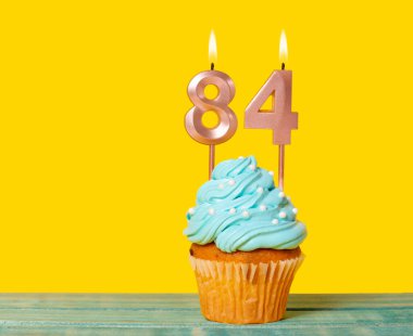 84 Numaralı Mumlu Doğum Günü Pastası Sarı Arkaplanda.