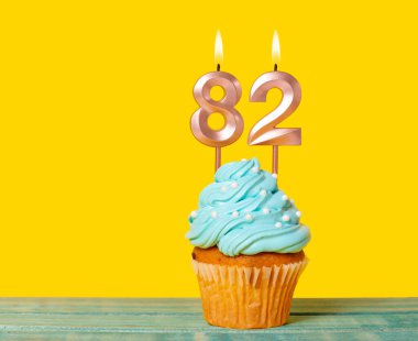 Sarı Arkaplanda 82 Numaralı Mumlu Doğum Günü Pastası.