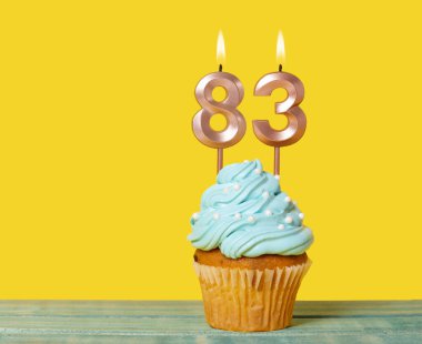 83 Numaralı Mumlu Doğum günü Pastası Sarı Arkaplanda.
