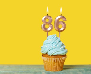 Sarı Arkaplanda 86 Numaralı Mumlu Doğum Günü Pastası.