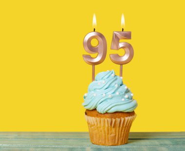 Sarı Arkaplanda 95 numaralı mumlu doğum günü pastası.