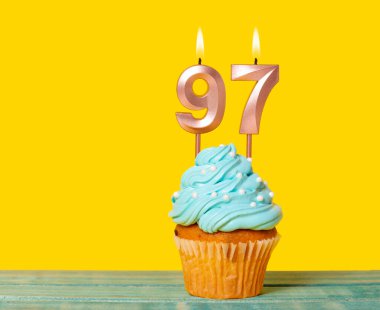 Sarı Arkaplanda 97 numaralı mumlu doğum günü pastası.