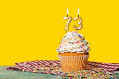 73 Numaralı Mumlu Doğum günü Pastası - Sarı Arkaplanda Fotoğraf.
