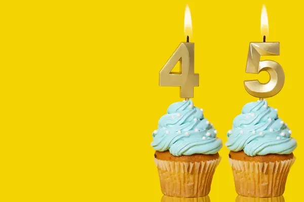 Verjaardagscupcakes Met Kaarsen Lit Vorming Van Het Nummer Foto Gele Stockfoto