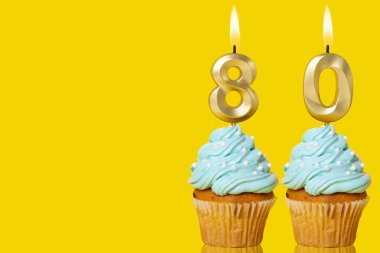 Sarı Arkaplanda 80 Numaralı Fotoğrafı Oluşan Mumlu Doğum günü Kekleri.