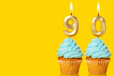 Doğumgünü Kekleri ve Mumlar Parlıyor 90 Numaralı Fotoğraf Sarı Arkaplanda.