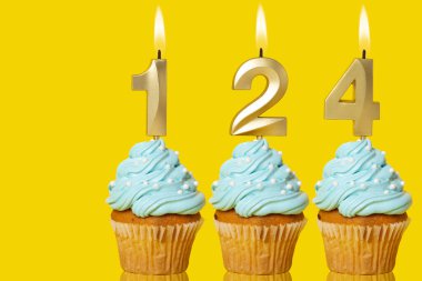 124 Numaralı Mum Işıklı Doğum Günü Kekleri Sarı Arkaplanda Fotoğraf.